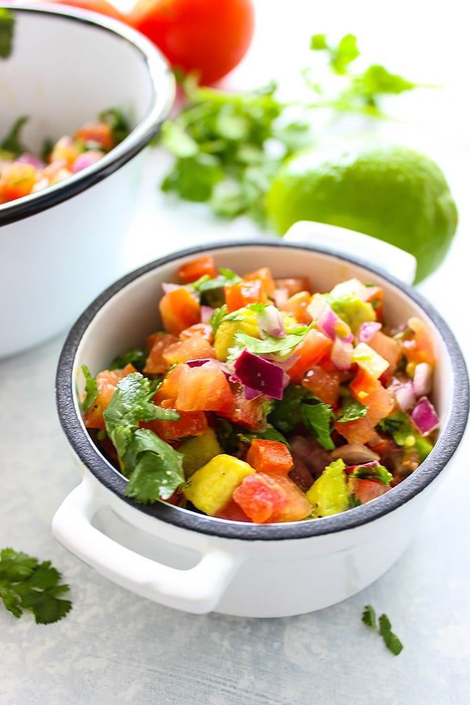 A quick and easy recipe for Pico De Gallo (Salsa Fresca) with fresh avocado, tomatoes, red onions, lemon juice and cilantro. Use it as a dip or topping for tacos!