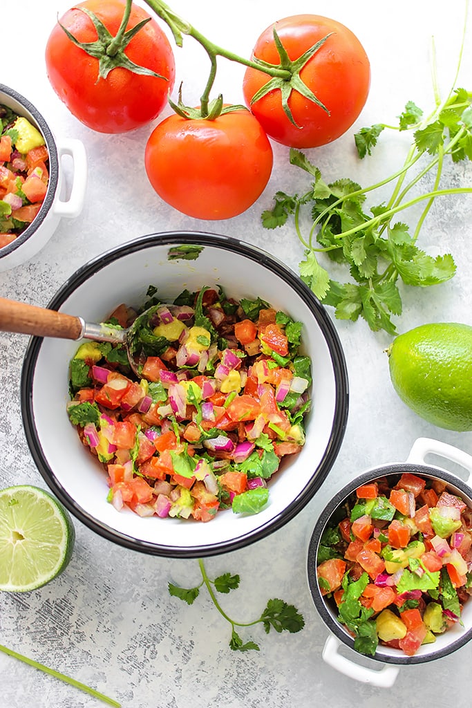 A quick and easy recipe for Pico De Gallo (Salsa Fresca) with fresh avocado, tomatoes, red onions, lemon juice and cilantro. Use it as a dip or topping for tacos!