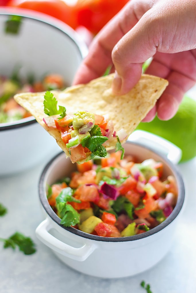 A quick and easy recipe for Pico De Gallo (Salsa Fresca) with fresh avocado, tomatoes, red onions, lemon juice and cilantro. Use it as a dip or topping for tacos!