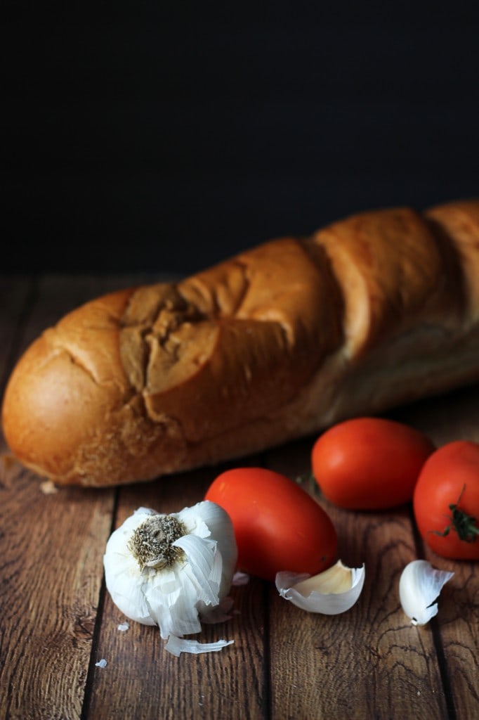 A healthy appetizer of grilled baguette slices rubbed with fresh garlic and topped with tomatoes, garlic, basil and crumbled feta cheese.