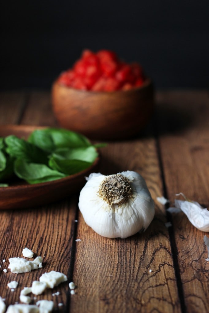 A healthy appetizer of grilled baguette slices rubbed with fresh garlic and topped with tomatoes, garlic, basil and crumbled feta cheese.