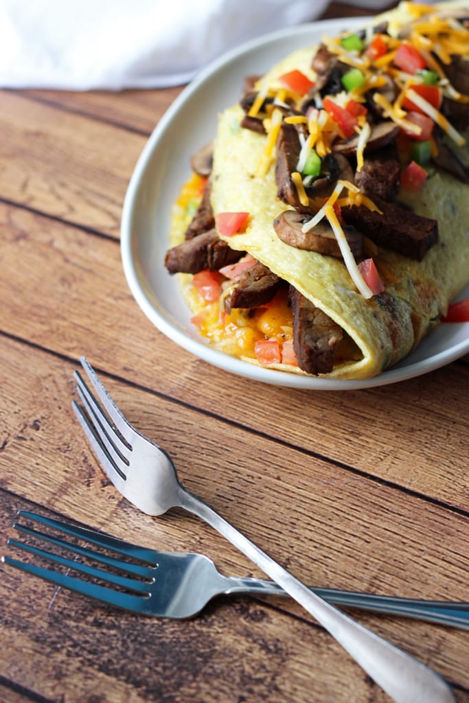 An IHOP copycat recipe for Big Steak Omelette: a giant omelette stuffed to the brim with steak, bell peppers, onions, cheese, hash browns and mushrooms!