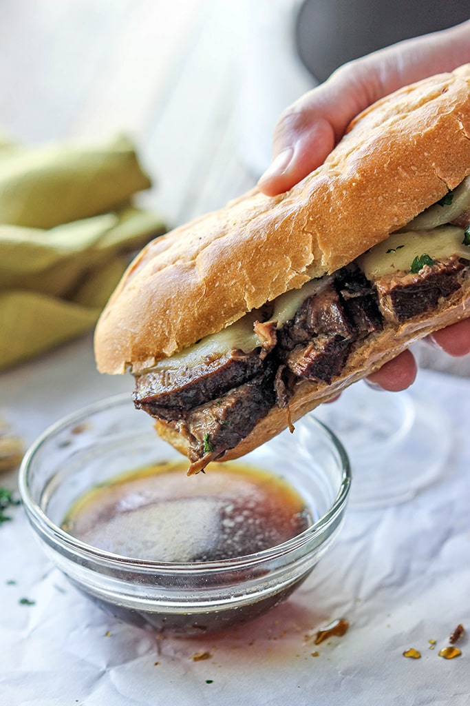 A slow cooker French Dip sandwich that's a perfect hot fix for cool weather. Dip, dip, dip it in some hearty au jus gravy!