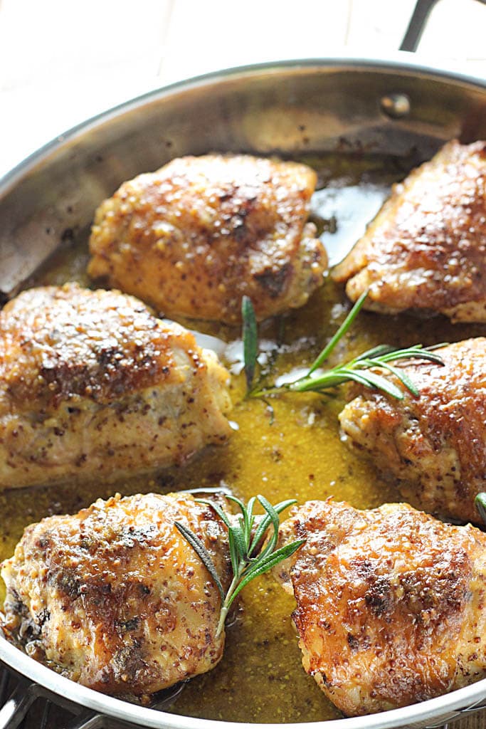 Perfectly seared and baked chicken thighs in a honey mustard sauce with hints of rosemary make this baked honey mustard chicken a great dinner.