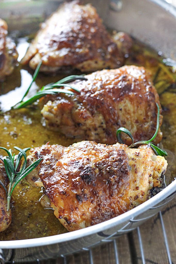 Perfectly seared and baked chicken thighs in a honey mustard sauce with hints of rosemary make this baked honey mustard chicken a great dinner.