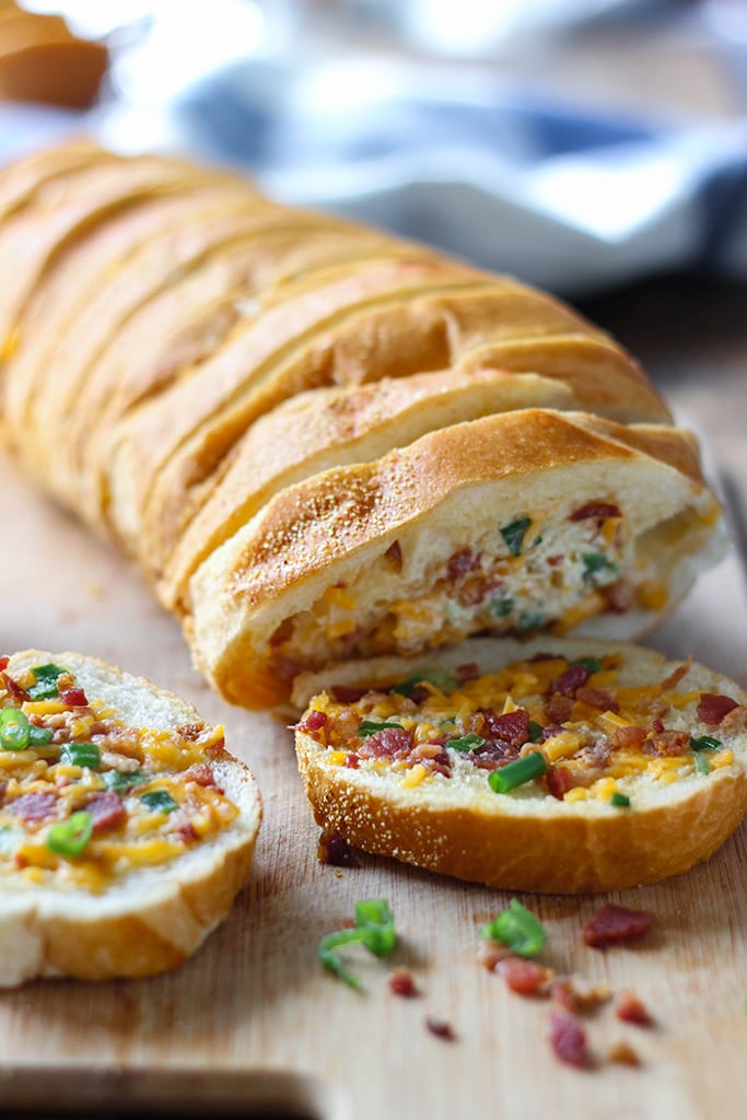 An easy cheesy bacon bread appetizer for a big crowd. With creamy butter, cheddar cheese, bacon pieces and green onions! 