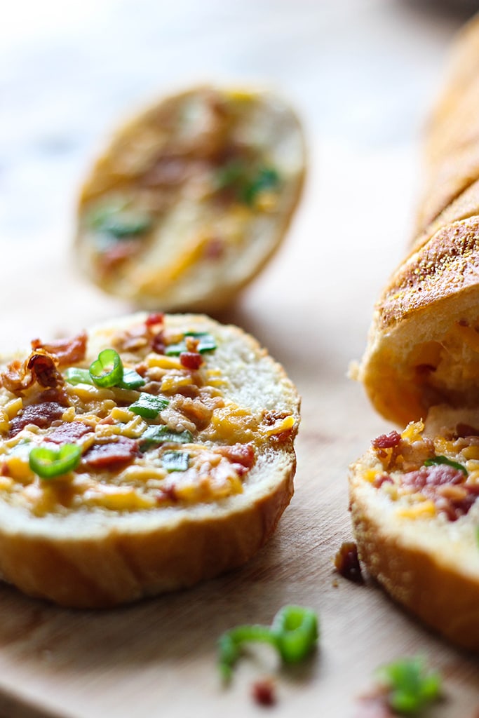 An easy cheesy bacon bread appetizer for a big crowd. With creamy butter, cheddar cheese, bacon pieces and green onions! 