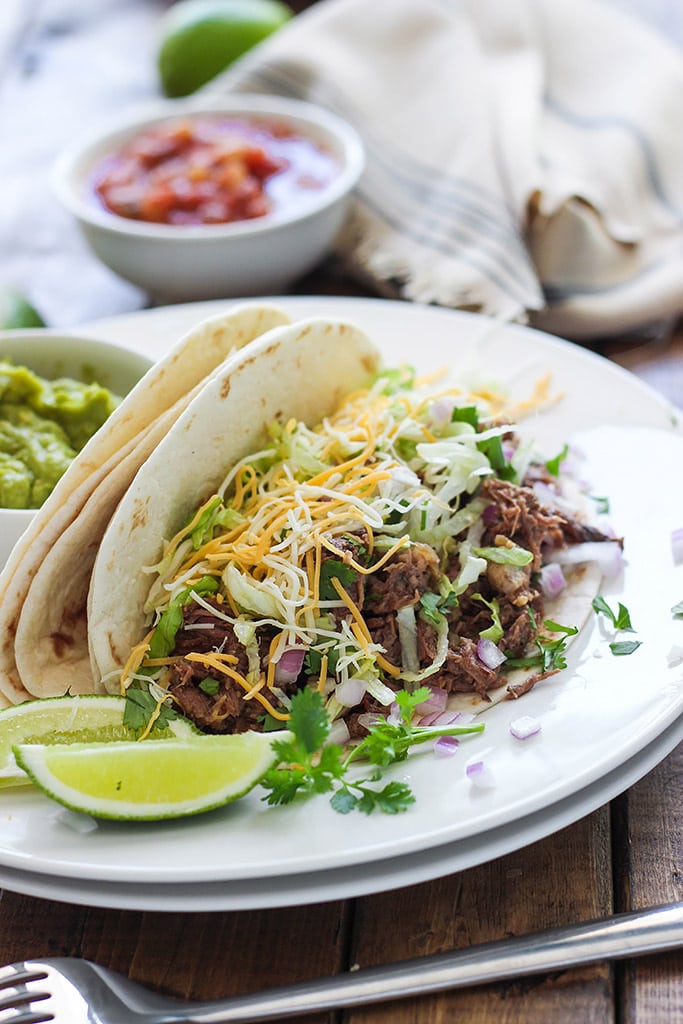 These slow cooker shredded beef tacos are summer slow cooking at its best! Pair it with your favorite toppings.