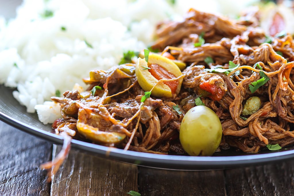 Fork-tender strands of pull apart flank steak simmering in a spicy tomato sauce makes this slow cooker Ropa Vieja something you should not miss.