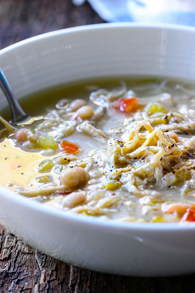 A slow cooker white chicken chili with tender chicken and beans simmered in a thick broth with green chilies, onions and celery. Pair it with your favorite toppings.