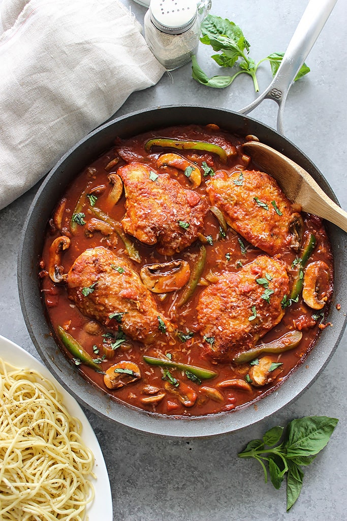 Skillet chicken cacciatore stewed in a robust red sauce with fresh peppers, mushrooms and basil is a hearty meal for 4. Serve over pasta with Parmesan cheese.