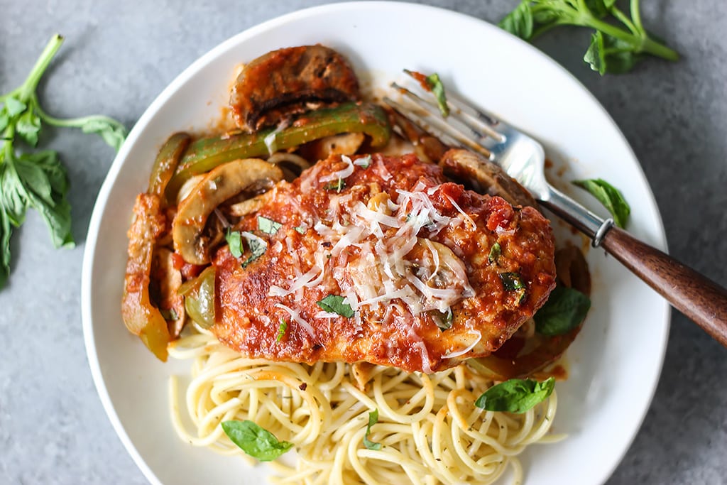 Skillet chicken cacciatore stewed in a robust red sauce with fresh peppers, mushrooms and basil is a hearty meal for 4. Serve over pasta with Parmesan cheese.