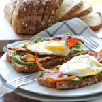 This open-faced breakfast sandwich is a quick and easy fix for mornings or brunch with chilled guacamole spread, crisp bacon and sunny side up eggs.