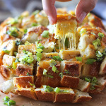 Bloomin' onion bread is the appetizer you're looking for to 'wow' guests. Cheesy, gooey strings of cheese meets crunchy, fresh green onions and poppy seeds!