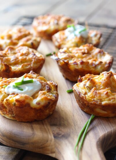 Several mashed potato puffs topped with sour cream and fresh chopped chives.