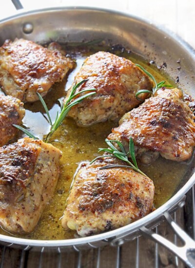 Perfectly seared and baked chicken thighs in a honey mustard sauce with hints of rosemary make this baked honey mustard chicken a great dinner.