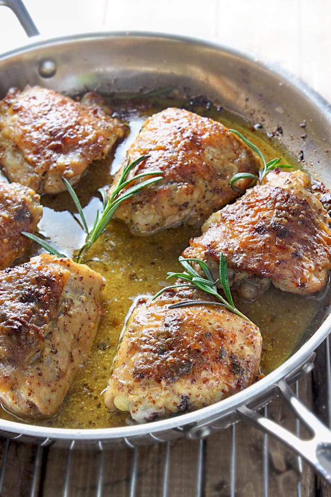 Perfectly seared and baked chicken thighs in a honey mustard sauce with hints of rosemary make this baked honey mustard chicken a great dinner.