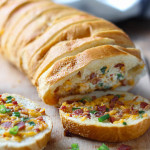 An easy cheesy bacon bread appetizer for a big crowd. With creamy butter, cheddar cheese, bacon pieces and green onions!