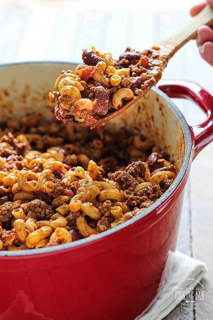 Chili mac and cheese on a wooden spoon.