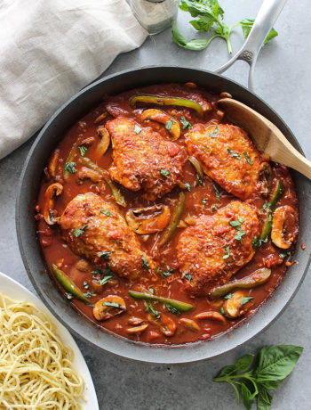 Skillet chicken cacciatore stewed in a robust red sauce with fresh peppers, mushrooms and basil is a hearty meal for 4. Serve over pasta with Parmesan cheese.
