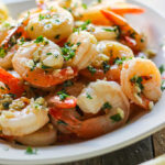 Shrimp scampi on a plate of pasta.