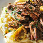 Shredded Mississippi pot roast on a bed of mashed potatoes and gravy.