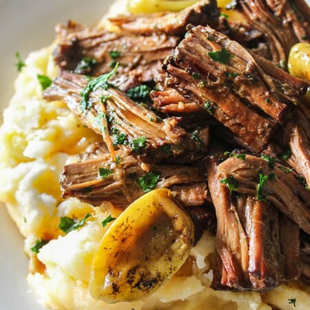 Shredded Mississippi pot roast on a bed of mashed potatoes and gravy.