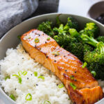 A bowl of honey garlic salmon with rice and broccoli.