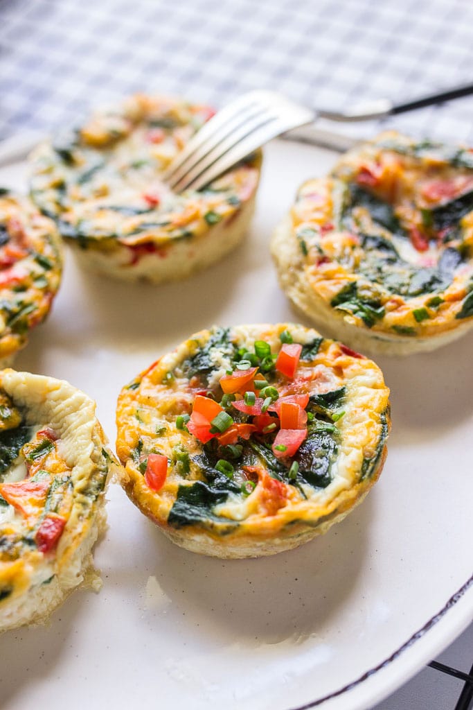 Close up shot of five healthy egg white muffin breakfast cups on a white plate.