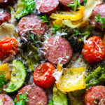 A close up picture of sausage and veggies with parsley and parmesan cheese.