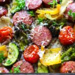 A close up picture of sausage and veggies with parsley and parmesan cheese.