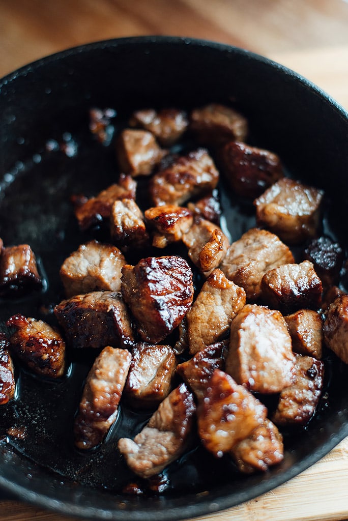 Bite-sized pieces of seared hibachi steak in a cast iron pan.