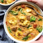 Slow cooker creamy tortellini soup in a white bowl.