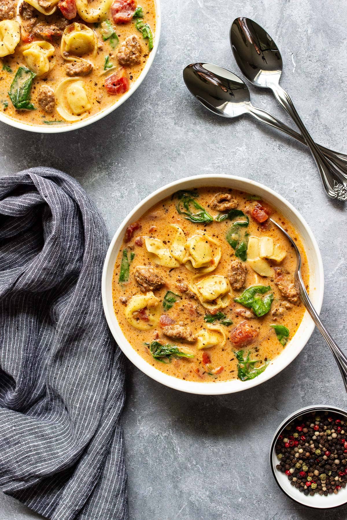 Two bowls of slow cooker creamy tortellini soup.