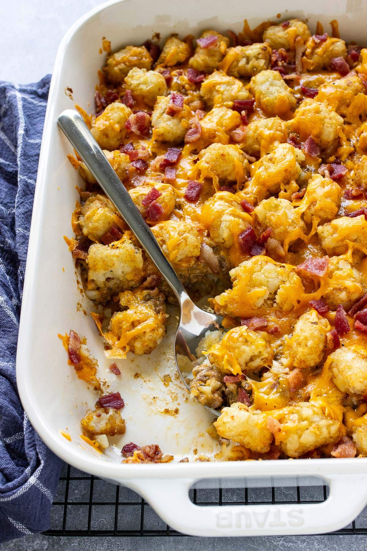 Bacon cheeseburger tater tot casserole in a white casserole dish.