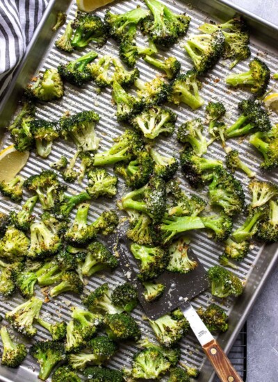 Garlic Parmesan roasted broccoli on a sheet pan topped with Parmesan cheese.