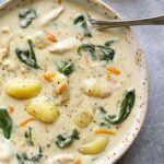 A bowl of slow cooker chicken gnocchi soup topped with cracked black pepper.