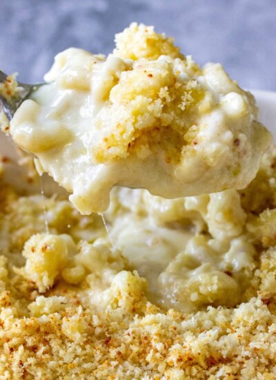 Creamy baked mac and cheese lifted with a spoon.