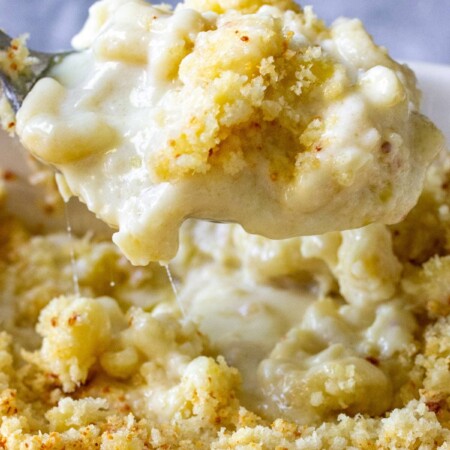 Creamy baked mac and cheese lifted with a spoon.