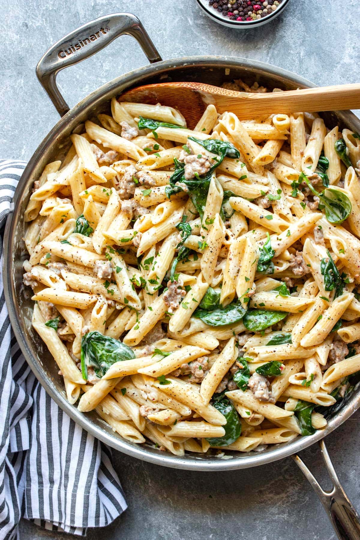 Creamy sausage pasta in a stainless steel skillet.