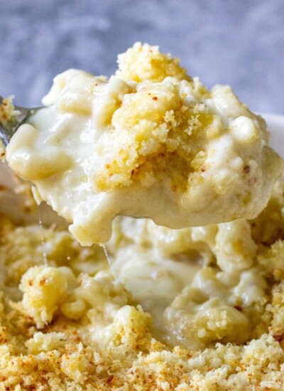 Creamy baked mac and cheese lifted with a spoon.