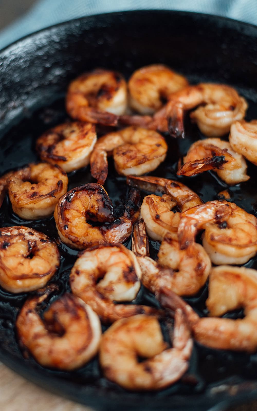 Hibachi shrimp being seared in a cast iron skillet.