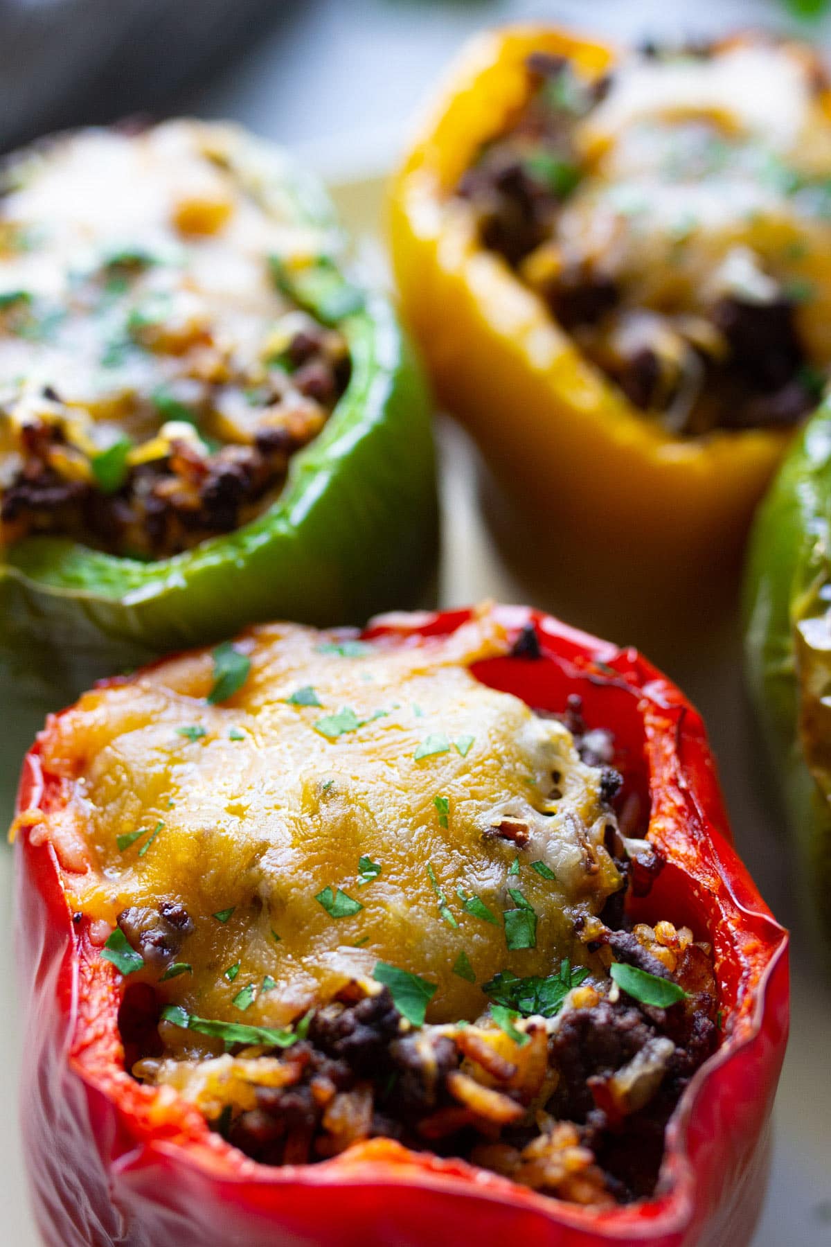Close up shot of red, green and yellow air fryer stuffed peppers.