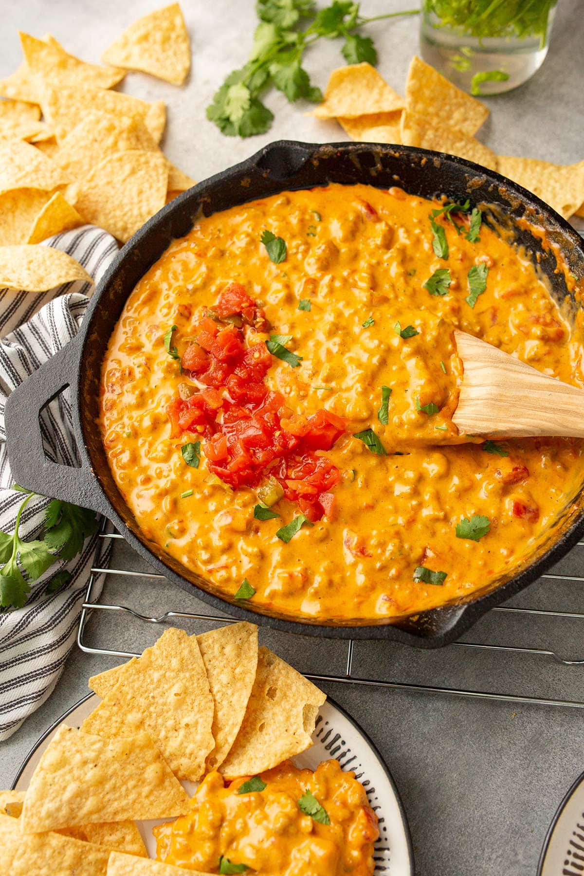 Velveeta Rotel sausage dip in a cast iron skillet with a plate of tortilla chips.
