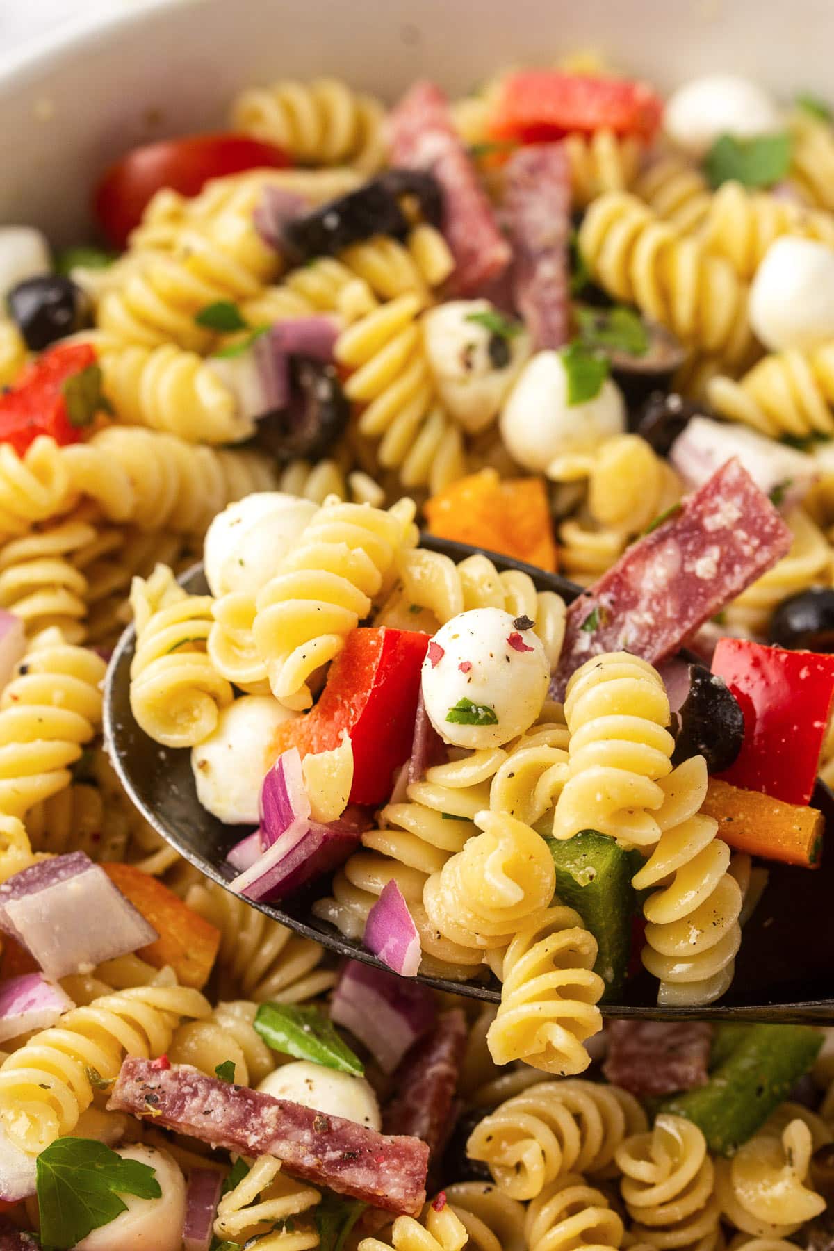 A close up shot of Italian salad in a mixing bowl.