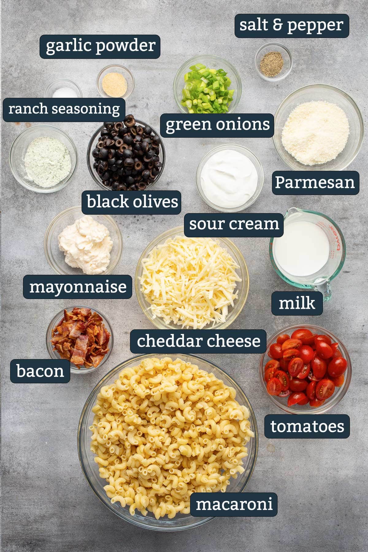 Ingredients to make bacon ranch pasta salad in prep bowls.