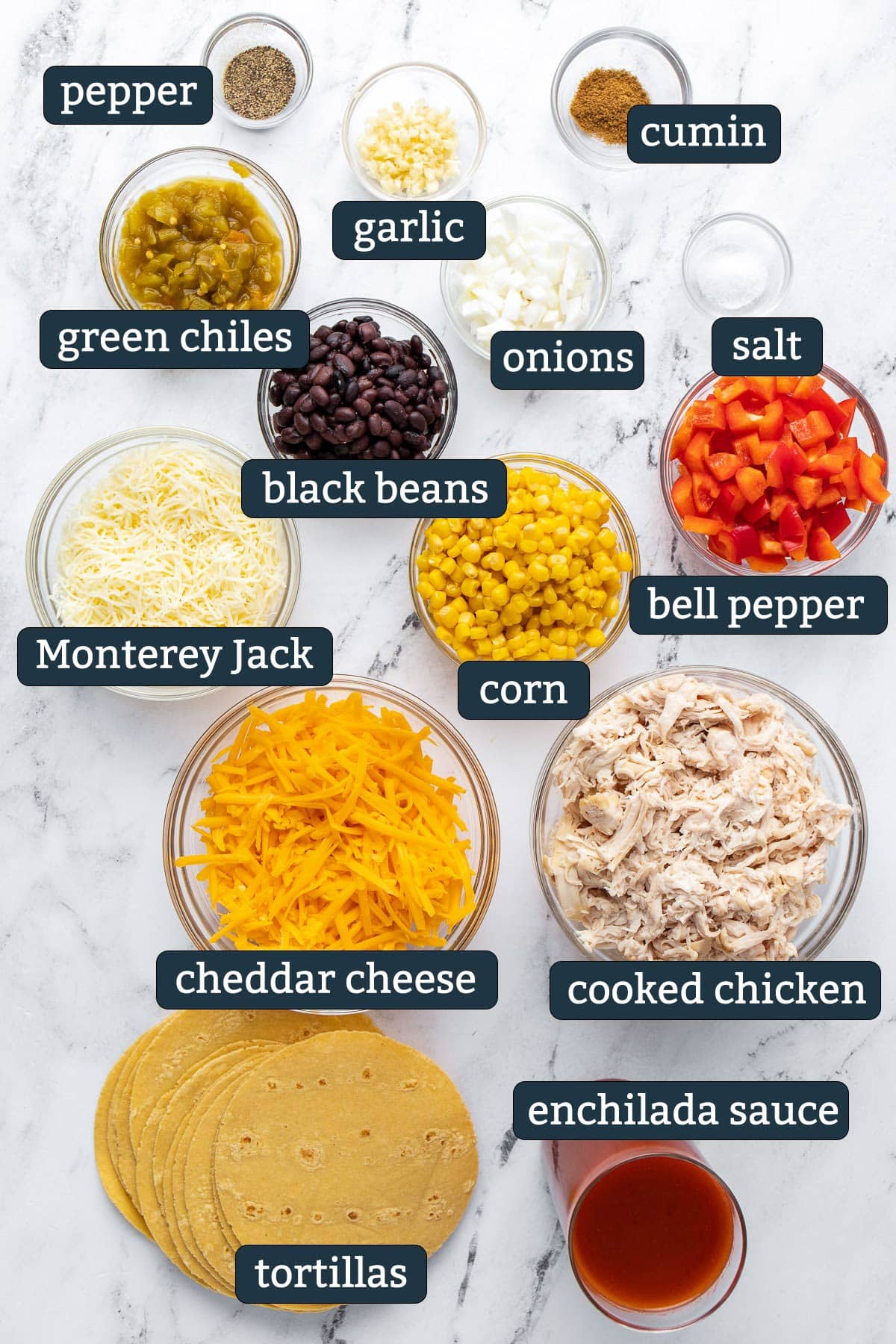 Ingredients to make chicken enchilada casserole in prep bowls.