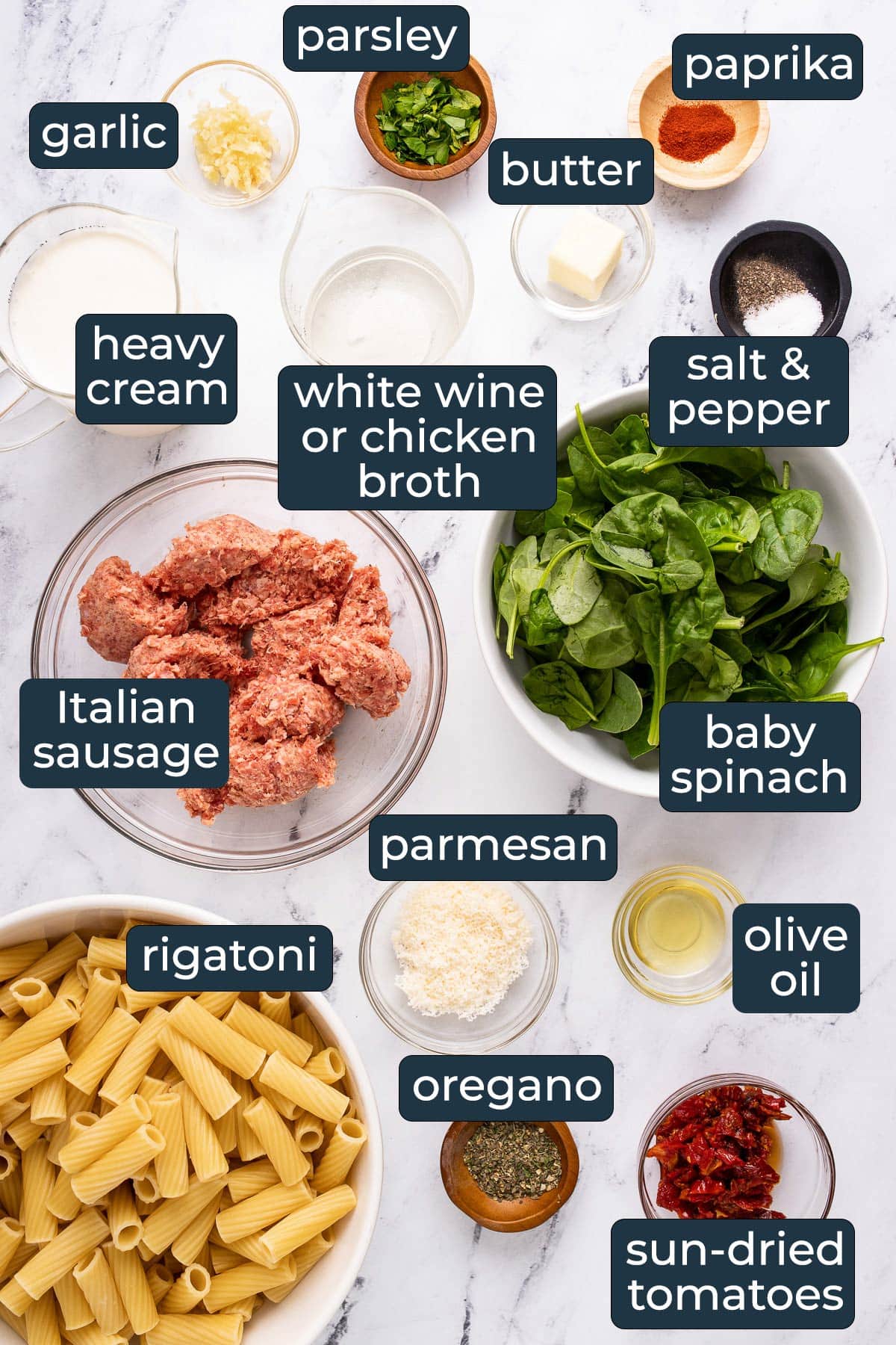 Ingredients to make creamy Tuscan sausage pasta in prep bowls.