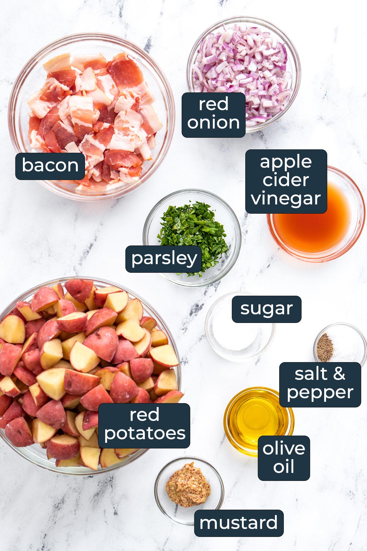 Ingredients to make German potato salad in glass prep bowls.