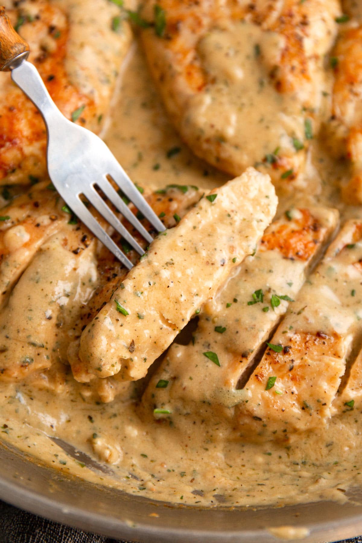 Creamy ranch chicken sliced into bite-sized pieces and smothered in sauce and topped with chopped fresh parsley.